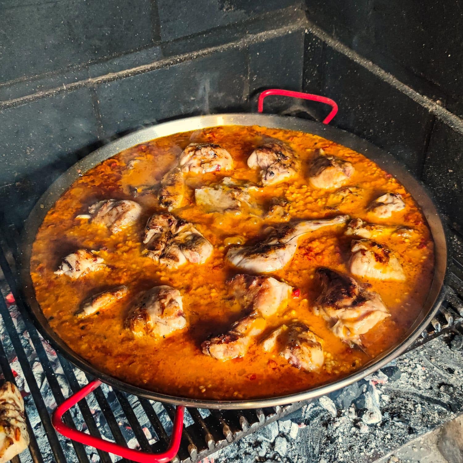 Fleischbasis (Kanninchen) für die Paella Pfanne auf dem bereits gekochten Reis.